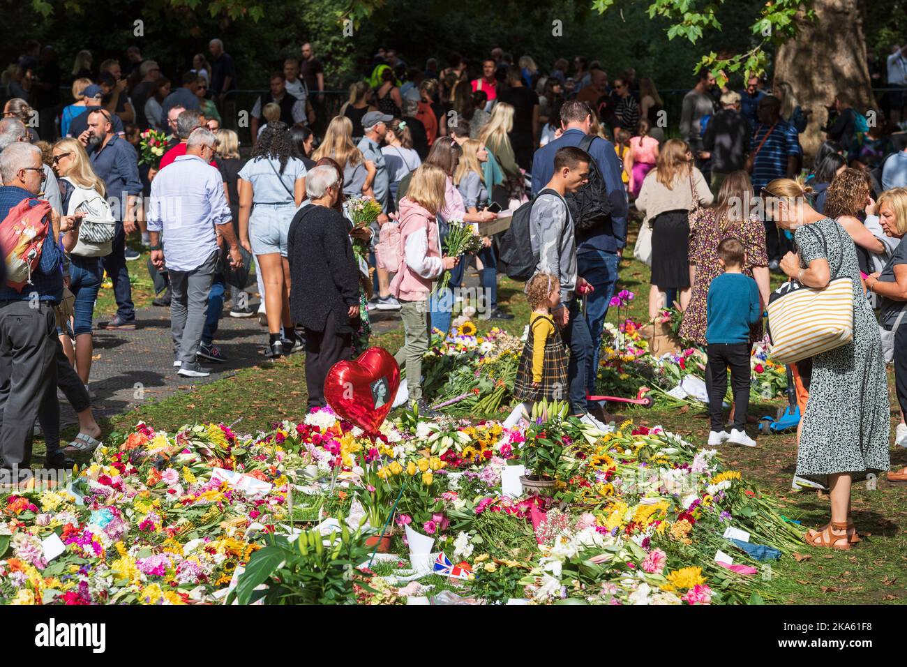Menschen, die die Blumen-Tribute im Green Park betrachten, die von Trauernden zum Anlass des Todes von Königin Elizabeth II. Hinterlassen wurden. Green Park, London, Großbritannien. 11. September 2022 Stockfoto