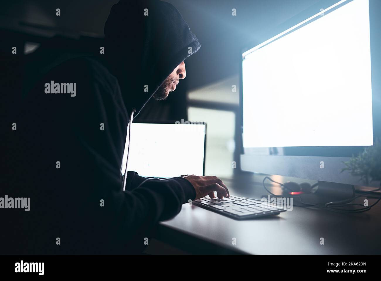 Hölle auf jeden Fall knacken diesen Code. Ein junger männlicher Hacker knacken einen Computer-Code im Dunkeln. Stockfoto
