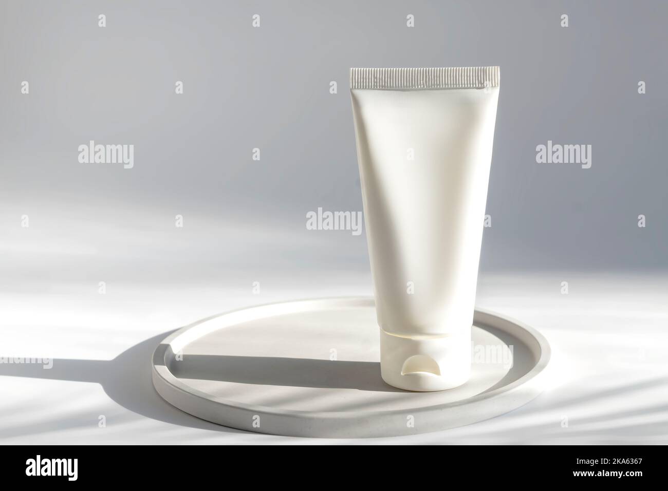 Flasche mit weißer Squeeze-Kosmetikcreme ohne Markenaufdruck. Weiße Kunststofftube für Gesichtscreme oder Lotion. Hautpflege oder Sonnenschutzmittel Kosmetik Stockfoto