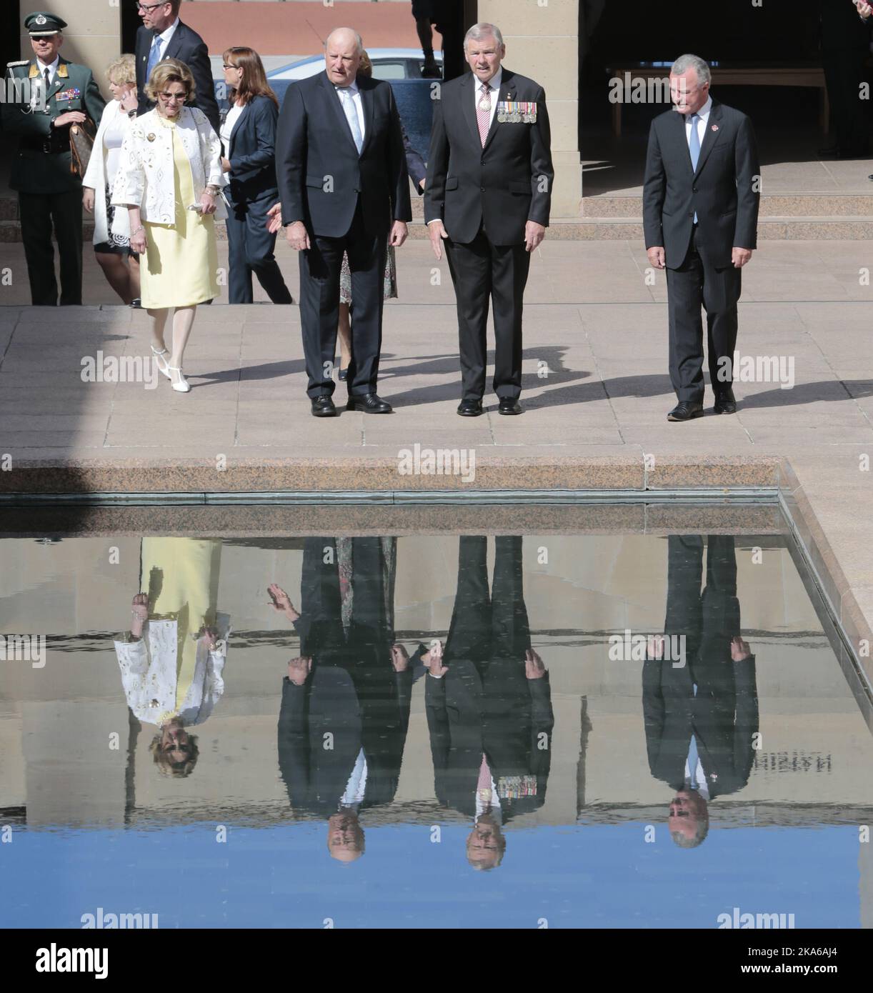 CANBERRA, AUSTRALIEN 20150223. Norwegens König Harald V (C) und Königin Sonja (L) spiegeln sich im Pool der Reflexion des Australian war Memorial mit dem Vorsitzenden des Australian war Memorial Konteradmiral Ken Doolan (2. R) und dem Direktor des Australian war Memorial Brendan Nelson (R) in Canberra wider. Photo= Lise Aaserud/NTB scanpix Stockfoto