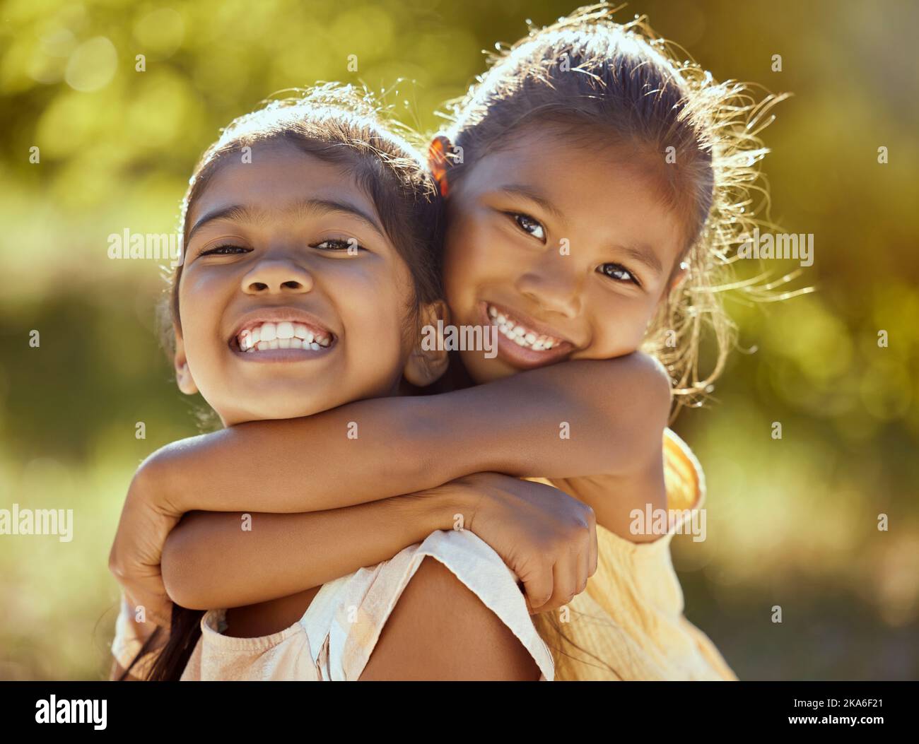 Mädchen, Umarmung und Liebe, Schwestern und glücklich im Porträt zusammen, junge Kinder im Freien und Familie in der Natur zu verbinden. Indische Kinder lächeln, Geschwister Stockfoto