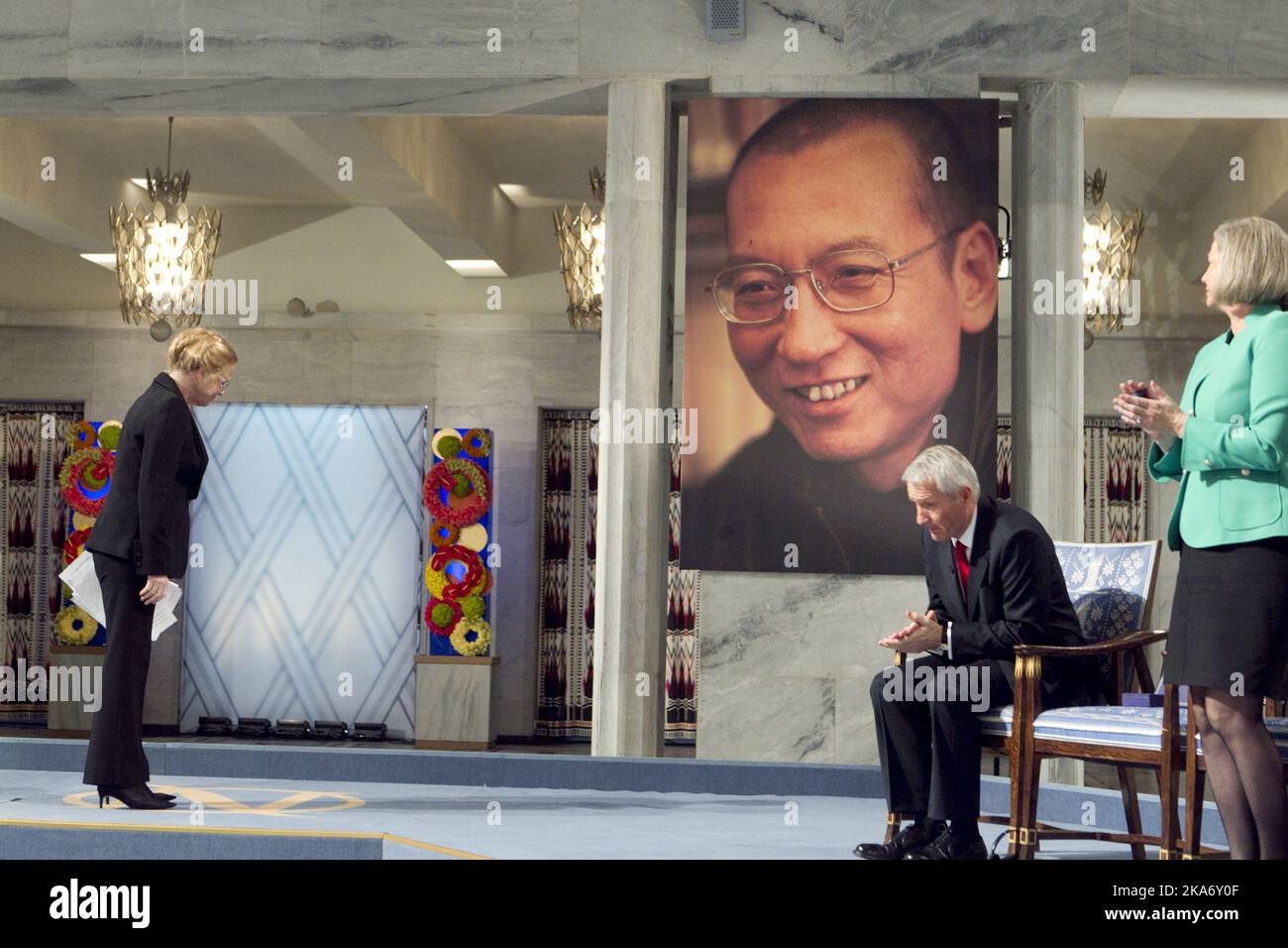 Oslo, 20170713: Der Friedensnobelpreisträger 2010, Liu Xiaobo, ist verstorben. File photo from December 10. 2010: Die Schauspielerin Liv Ullmann begrüßt das Porträt von Liu Xiaobo bei der Verleihung des Friedensnobelpreises im Rathaus von Oslo am Freitag. Der Vorsitzende des Nobelkomitees Thorbjørn Jagland und das Ausschussmitglied Kaci Kullmann Five (rechts). Der Friedensnobelpreis 2010 wird an den chinesischen Dissidenten Liu Xiaobo verliehen. Xiaobo wird während der Zeremonie von einem leeren Stuhl auf dem Podium vertreten, da er in China inhaftiert ist. POOL. Foto: Heiko Junge / NTB scanpix Stockfoto