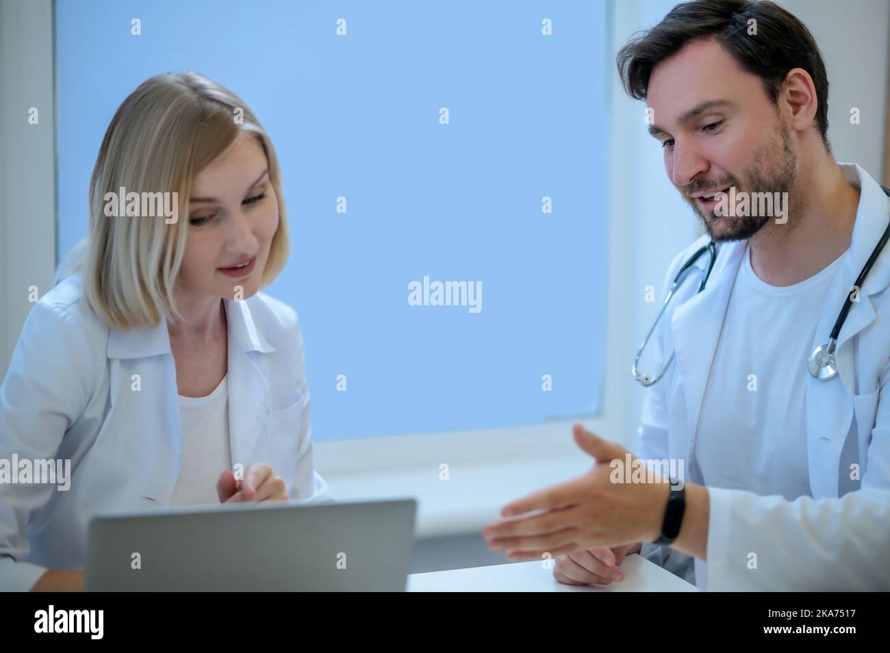 Zwei Ärzte sitzen dicht und diskutieren etwas Stockfoto