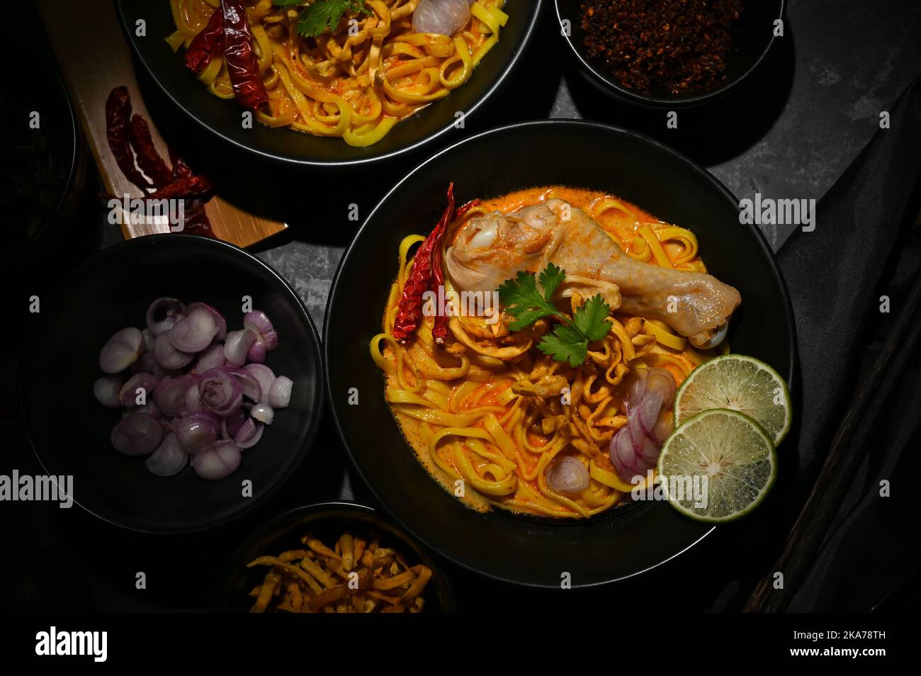 Blick von oben, traditionelles nordthailändisches Speisekonzept, leckere und schmackhafte, würzige cremige Kerrosuppe mit Hühnchen- und Eiernudeln oder Khao Soi Kai. Stockfoto