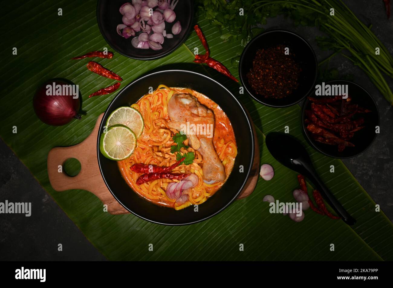 Blick von oben, Khao Soi Kai oder einzigartiges nordthailändisches würziges Kerri mit Eiernudeln, Huhn und Gemüse. Stockfoto