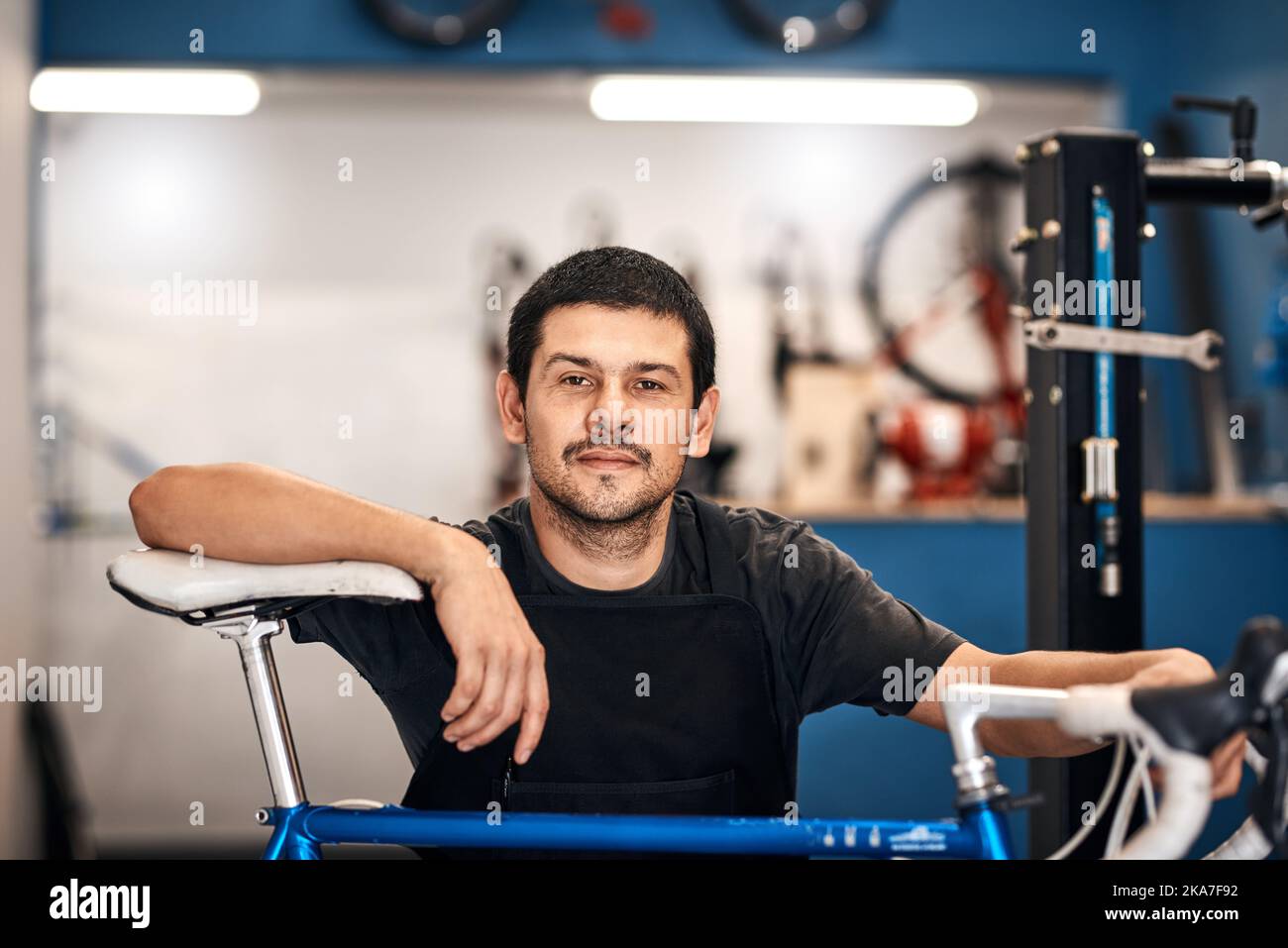 Wenn es um Fahrräder geht, weiß ich nicht darüber. Ein Mann, der in einer Fahrradwerkstatt arbeitet. Stockfoto