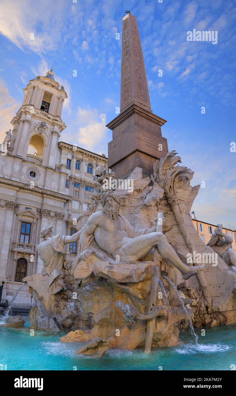 Stadtansicht von Rom, Italien: Brunnen der vier Wassermengen mit einem ägyptischen Obelisken auf dem Navon-Platz: Auf dem Hintergrund die Kirche Sant’Agnese in Agone. Stockfoto