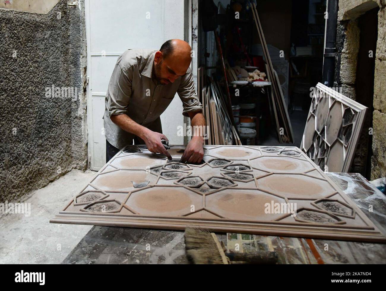 Damaskus, Syrien. 31. Oktober 2022. Ein syrischer Handwerker trägt eine zähflüssige Paste auf vorgezeichnete Muster auf einem Brett auf, um eine syrische Wand- und Deckendekoration zu schaffen, die als Damascene-Malerei oder Ajami in einer Werkstatt in Damaskus, Syrien, am 31. Oktober 2022 bekannt ist. Ajami ist ein traditionelles Handwerk, das für die Inneneinrichtung alter Häuser in Syrien verwendet wird.Quelle: Ammar Safarjalani/Xinhua/Alamy Live News Stockfoto