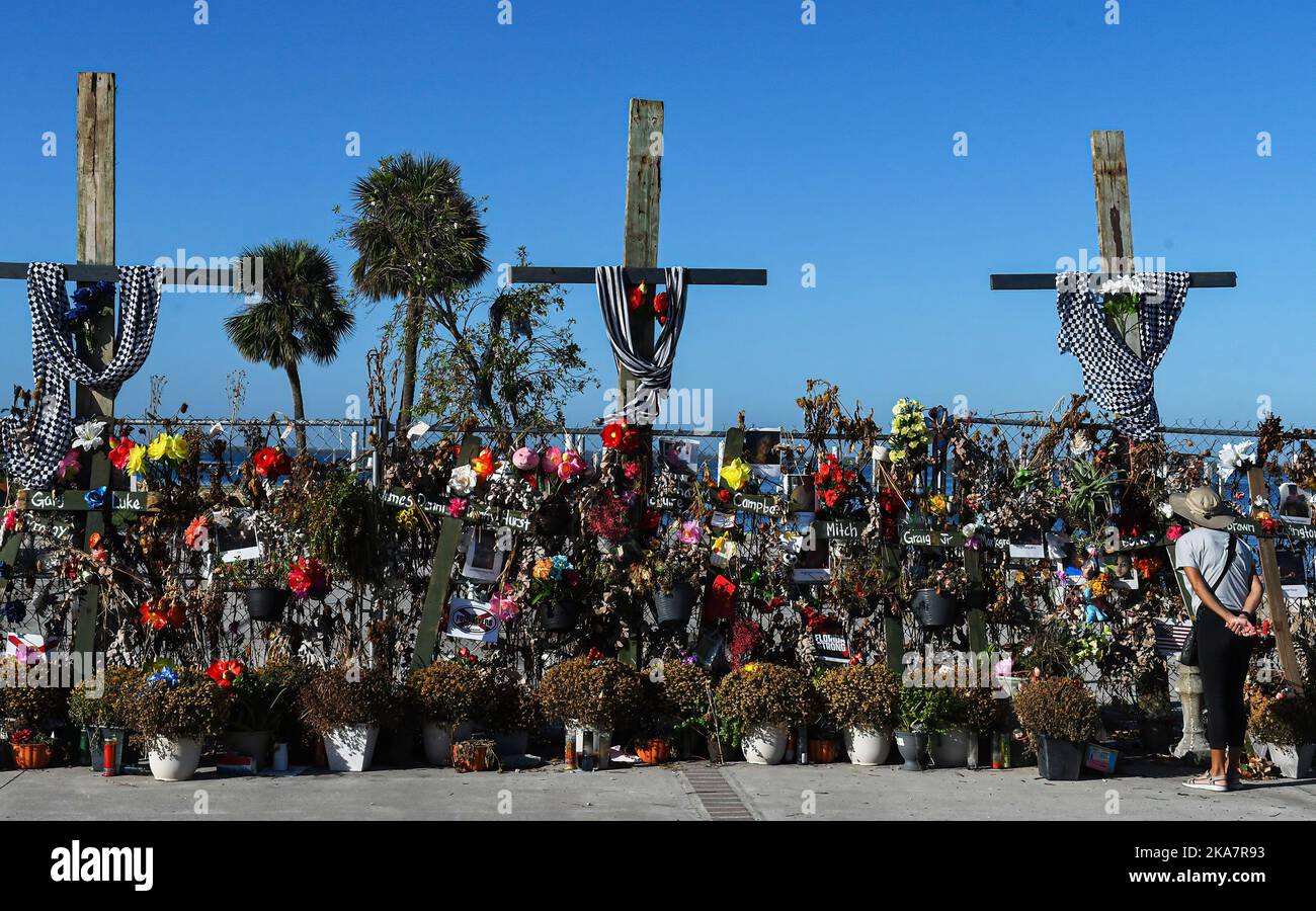 Fort Myers, Usa. 31. Oktober 2022. Eine Frau blickt im Centennial Park in Fort Myers, Florida, auf ein provisorisch anhaltendes Mahnmal mit Blumen, Kreuzen und Fotos für die Opfer des US-Unfallheers Ian. Der Sturm verursachte schätzungsweise $67 Milliarden versicherte Schäden und mindestens 127 stürmbedingte Todesfälle in Florida. Kredit: SOPA Images Limited/Alamy Live Nachrichten Stockfoto