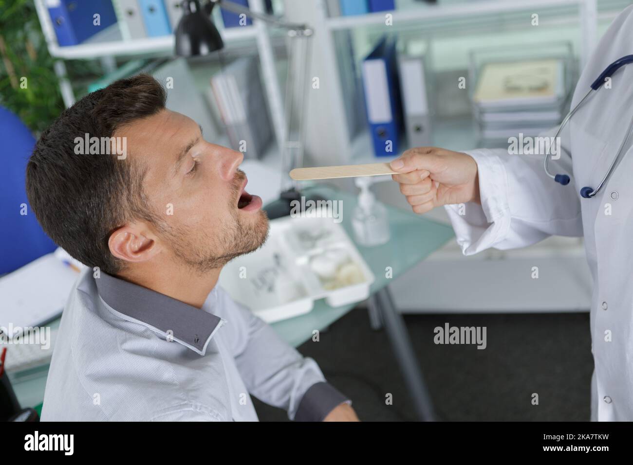 Junger Mann, der sich von einem männlichen Arzt untersuchen ließ Stockfoto