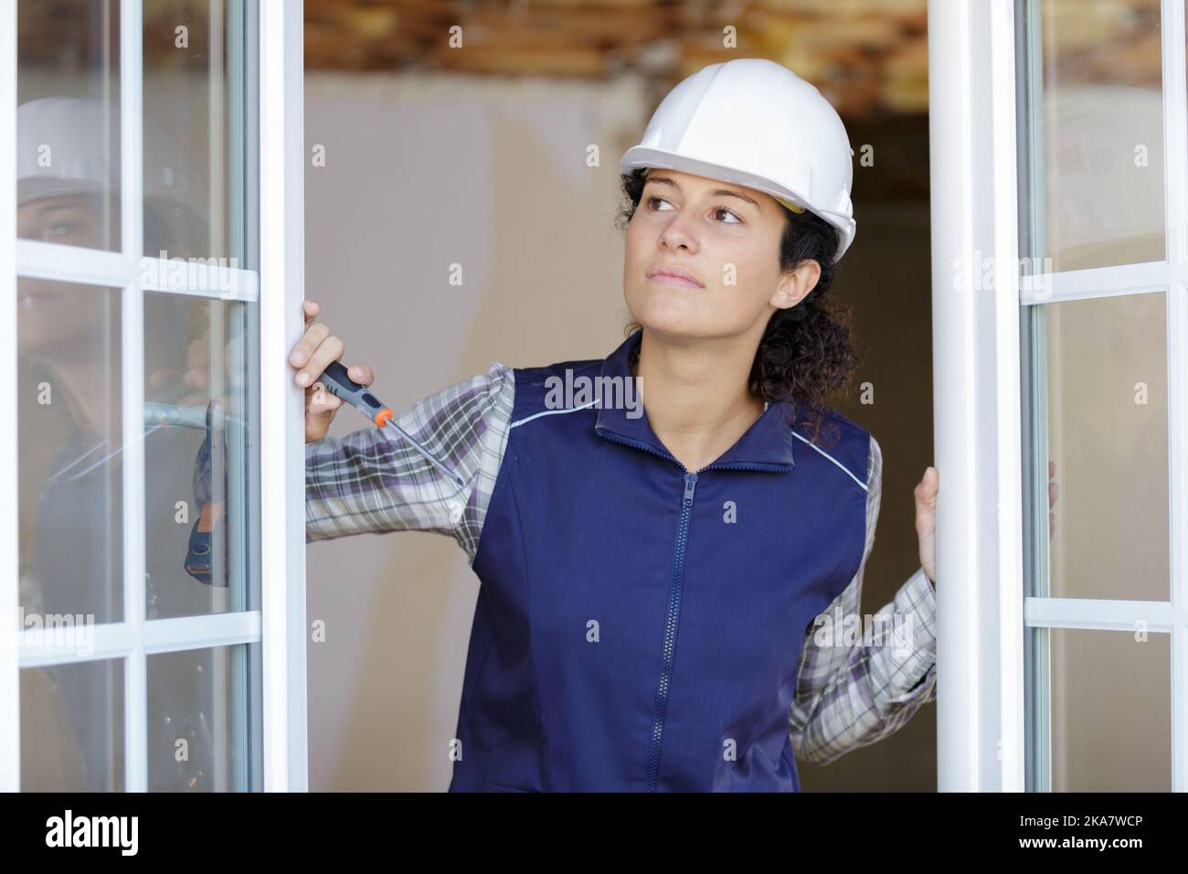 Porträt einer Arbeiterin, die Fenster überprüft Stockfoto