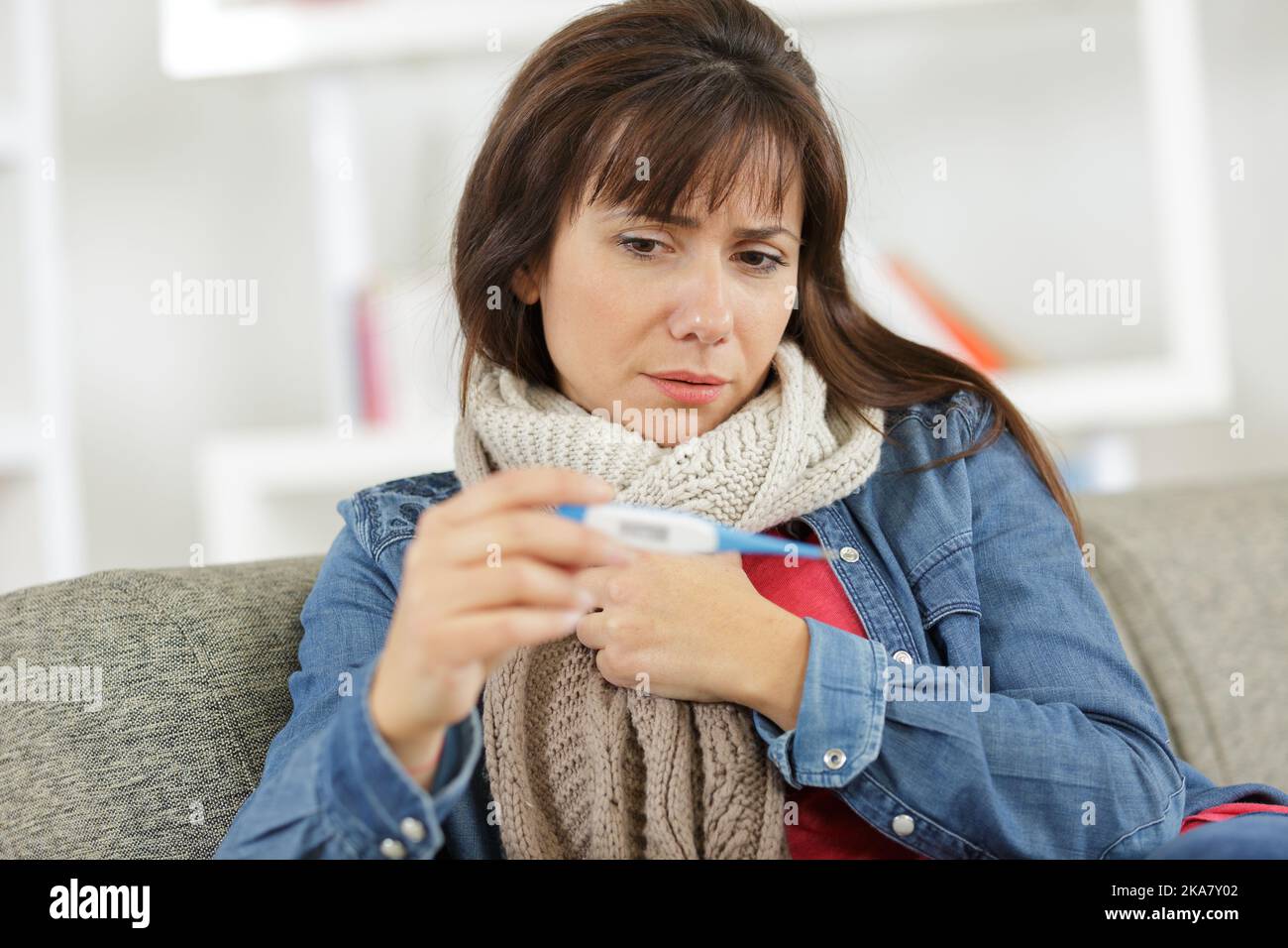 Kranke Frau mit Thermometer Stockfoto