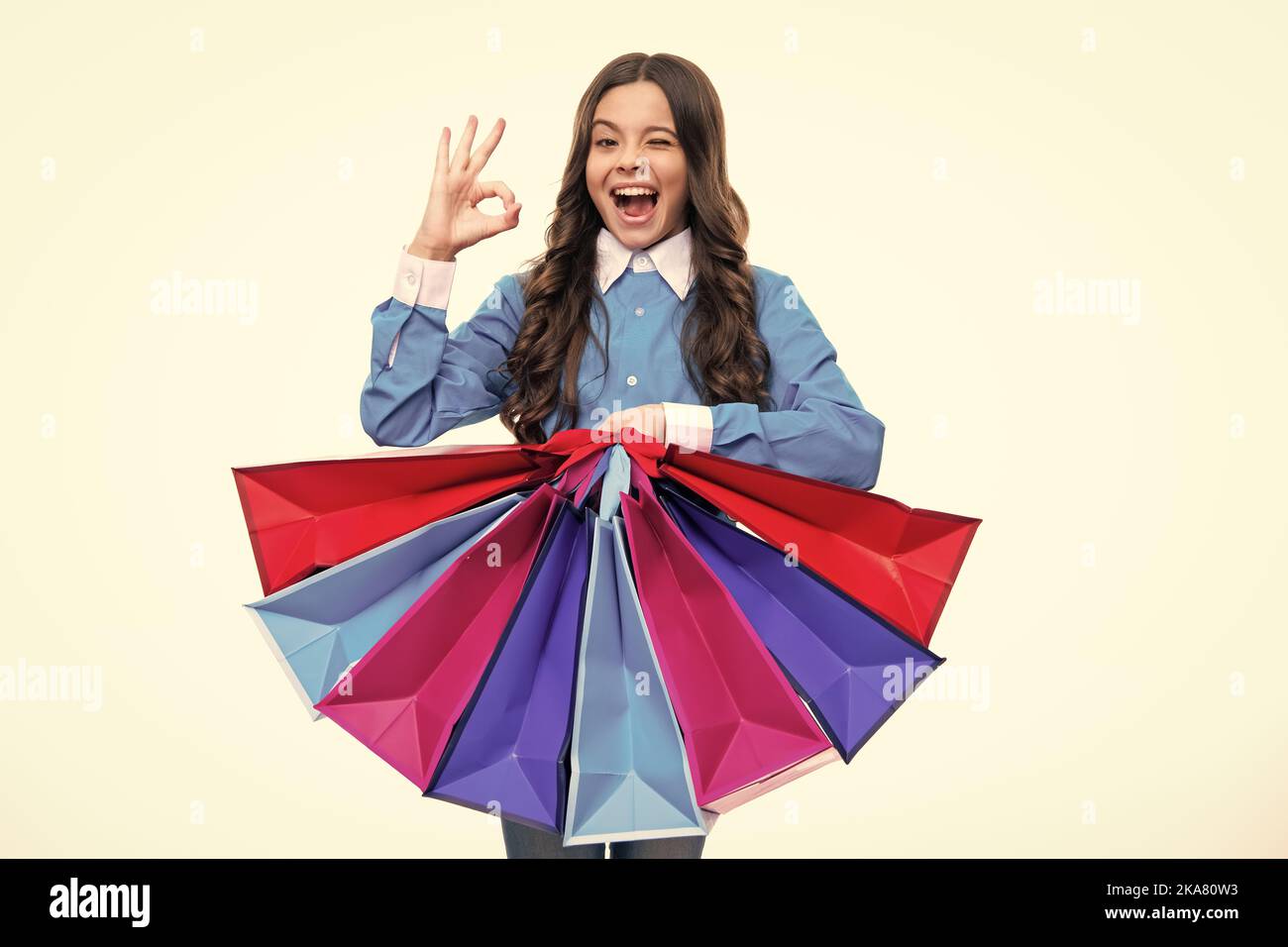 Aufgeregtes Gesicht. Lustige teen Mädchen halten Einkaufstasche genießen Verkauf isoliert auf weiß. Portrait von Teenager Schülerin ist bereit, einkaufen zu gehen. Begeistert Stockfoto