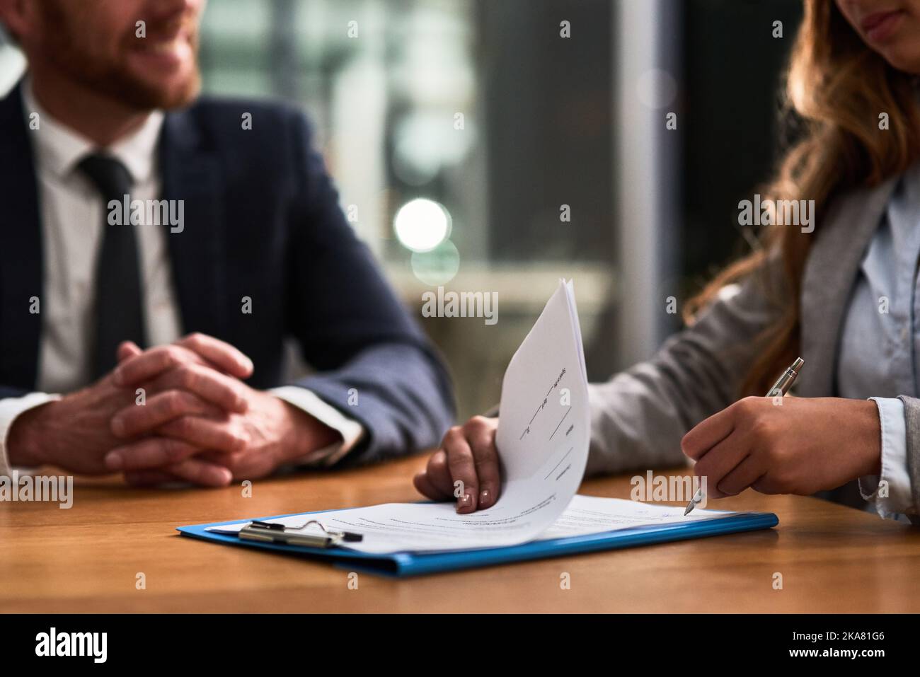 Eine Geschäftsfrau und ein Geschäftsmann, die zusammen an einem Schreibtisch Schreibarbeit erledigen. Stockfoto