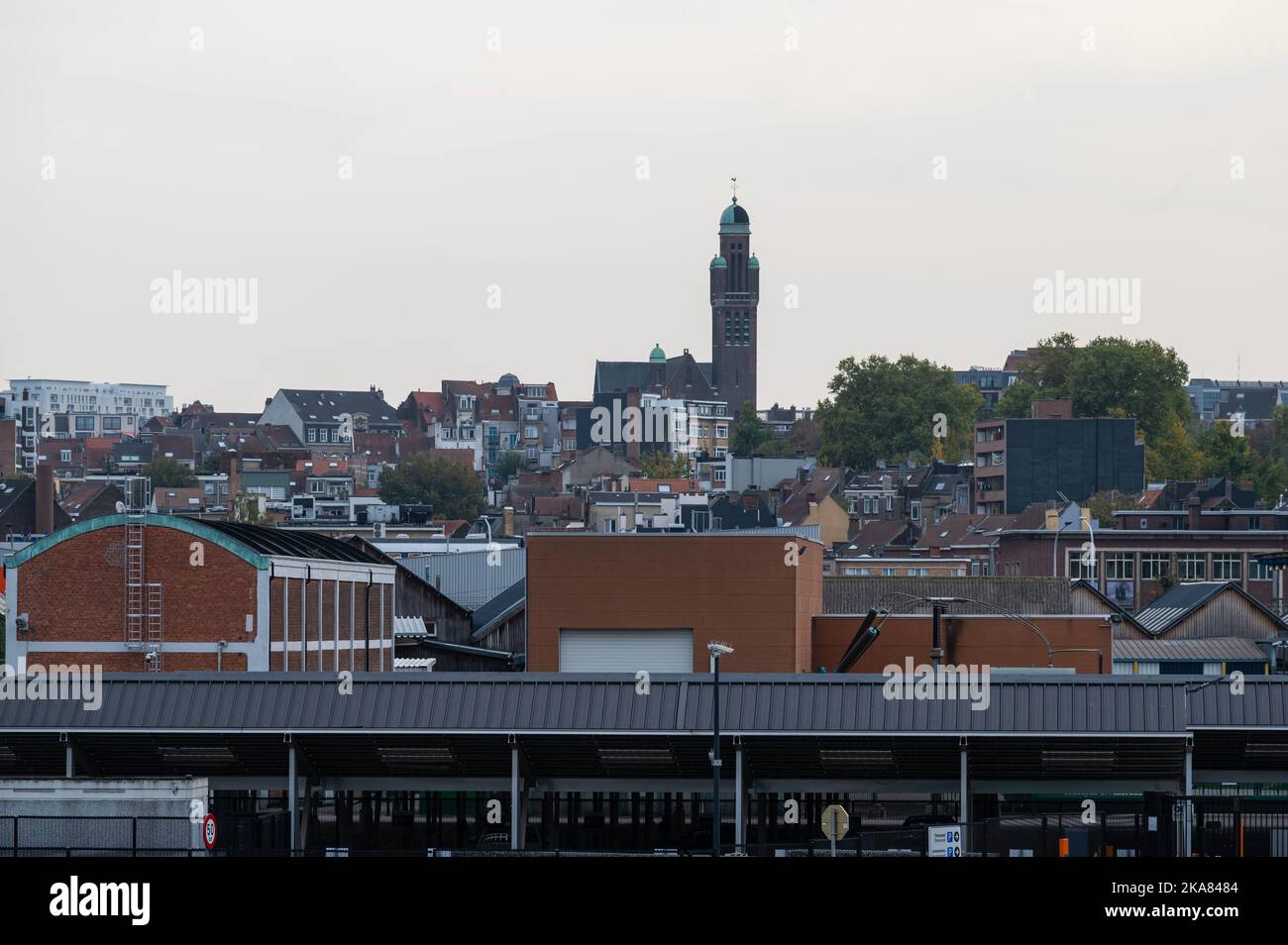 Schaerbeek, Brüssel, Belgien, 10 30 2022 - Blick über die Industrietätigkeit und den Turm der Kirche der Heiligen Familie Stockfoto
