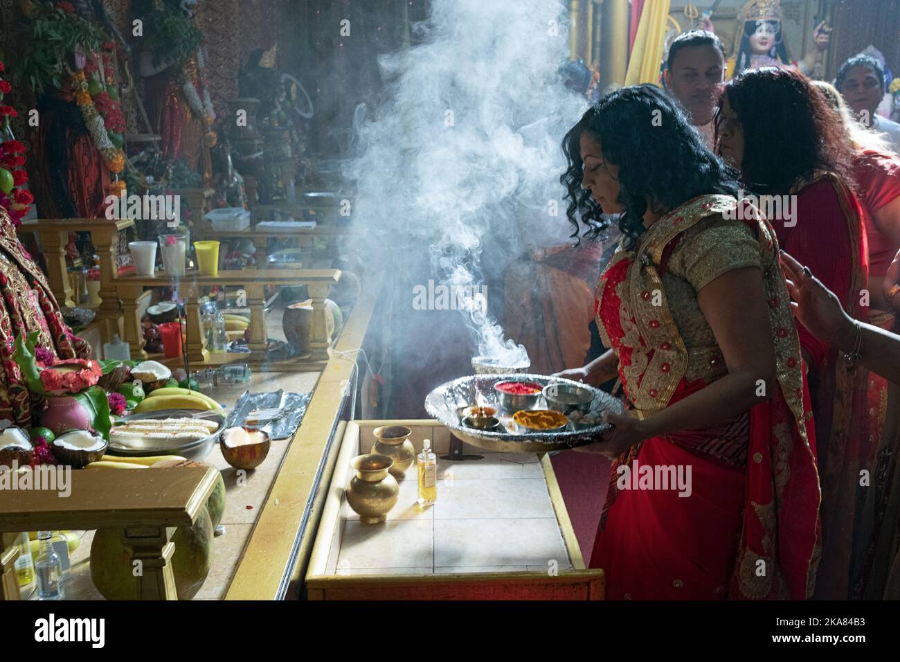 Fromme hinduistische Anhänger opfern ihren Gottheiten in einem hinduistischen Tempel im Ozone Park, Queens, New York City. Stockfoto