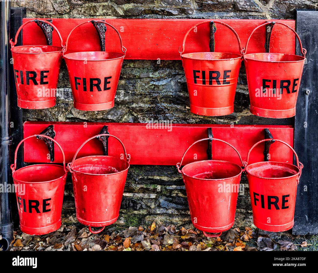 Heritage Red Fire Eimer hängen am Bahnhofssteig.an der Woody Bay Station auf der Lynton and Barnstaple Railway, Lynton, North Devon, England. Stockfoto