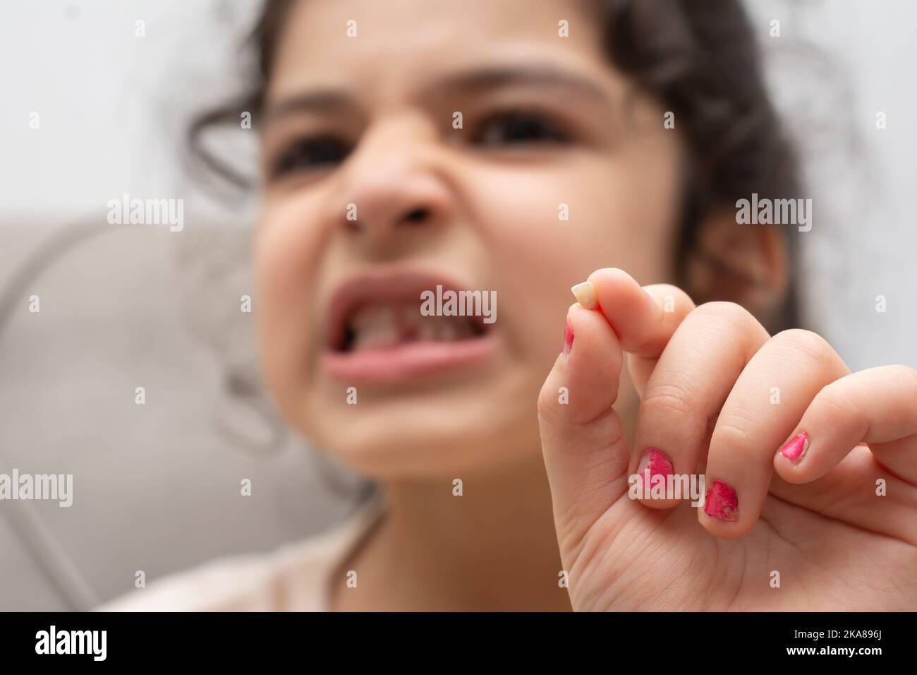Kleines Mädchen, das ihren ersten fehlenden Milchzahn zeigt Stockfoto