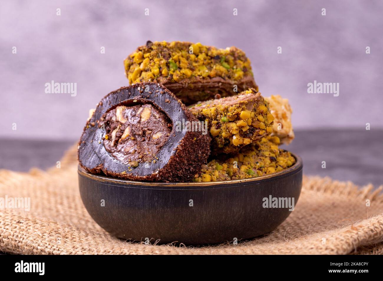 Gemischte türkische Delight-Sorten auf dunklem Hintergrund. Türkische Köstlichkeiten mit Pistazien, Haselnüssen und Früchten. Nahaufnahme Stockfoto