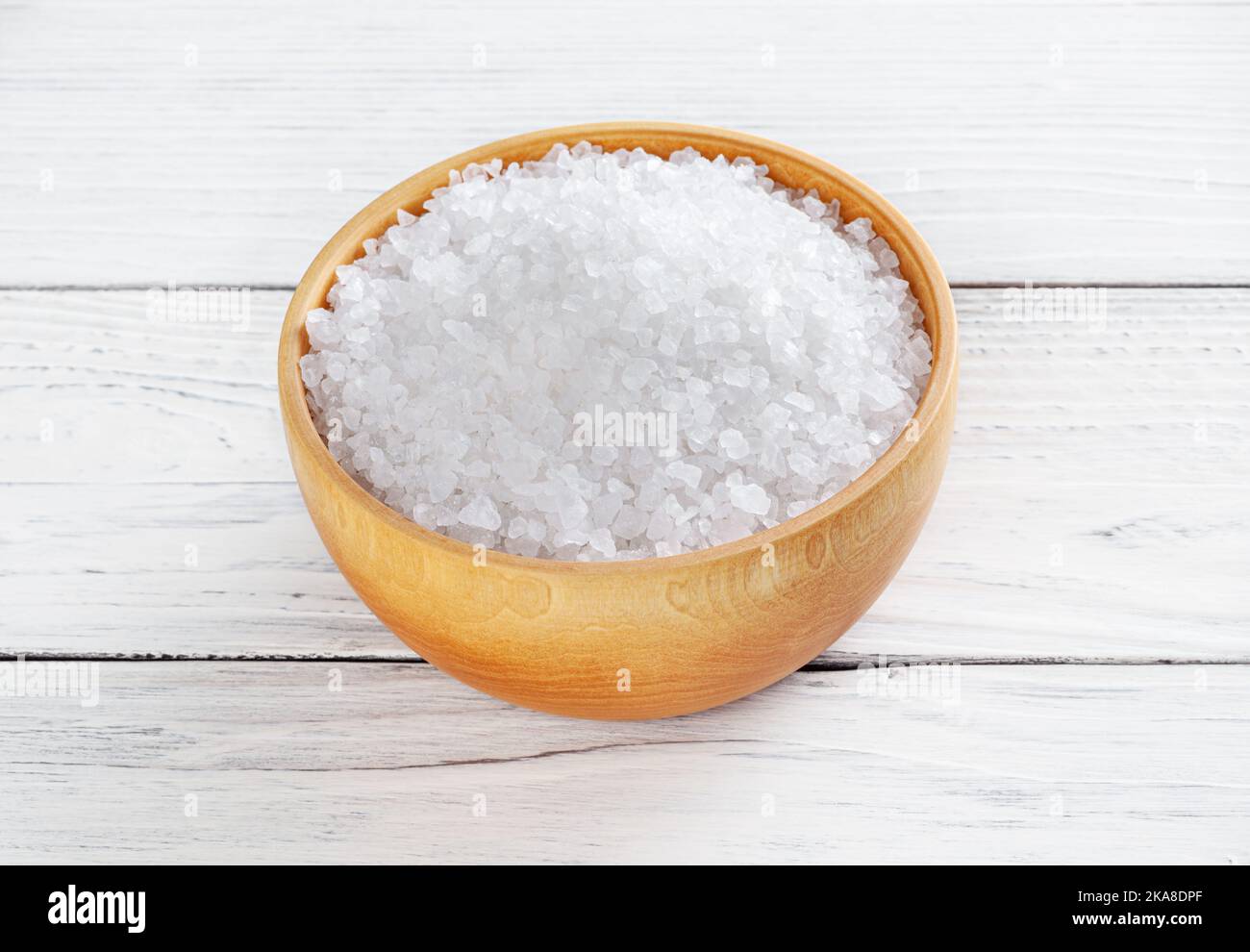Meersalz in Holzschale auf weißer Holztisch Stockfoto