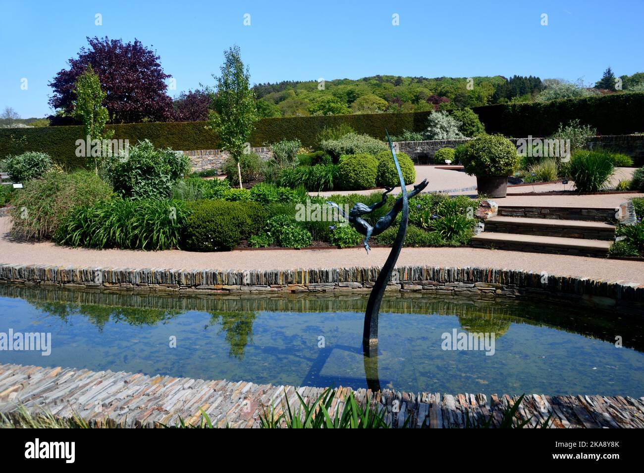 Die „Water Girl“-Bronzeskulptur im Teich im Cool Garden im RHS Garden Rosemoor, Torrington, North Devon, England, Großbritannien Stockfoto