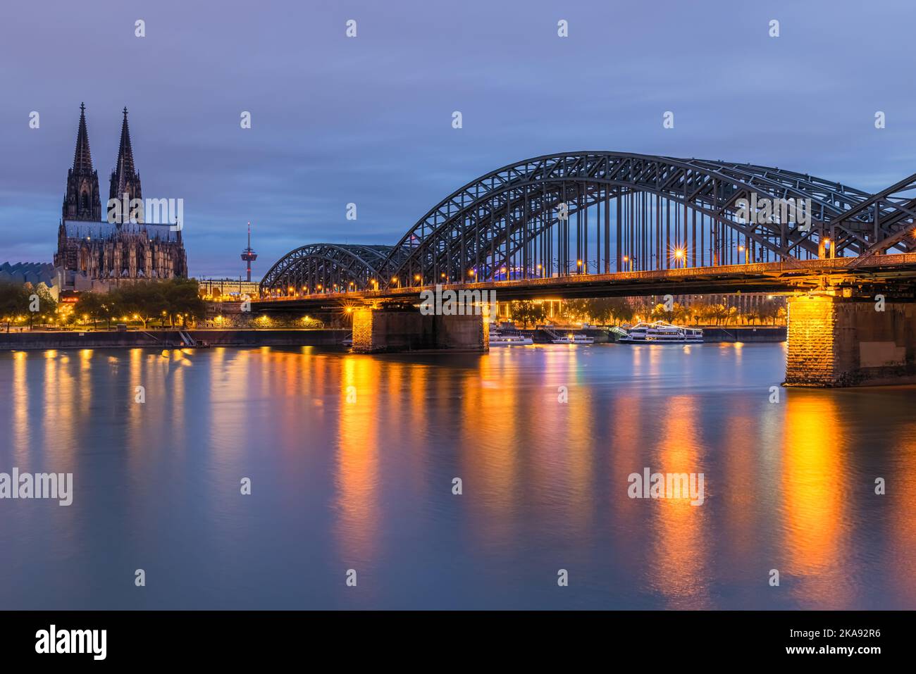 Ein Abend in Köln mit dem Dom und der Hohenzollernbrücke nach Sonnenuntergang. Stockfoto