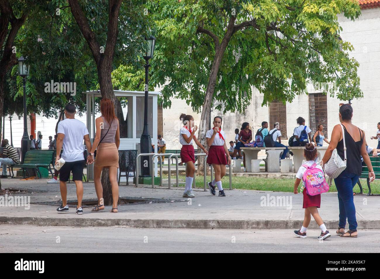 Kubanische Kinderpioniere in Uniform spazieren in einer Stadtecke, in der sich ein kleiner Park befindet. Stockfoto