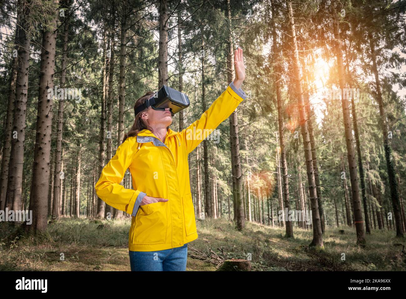 Frau mit Virtual-Reality-Headset, die in einem Wald steht Stockfoto