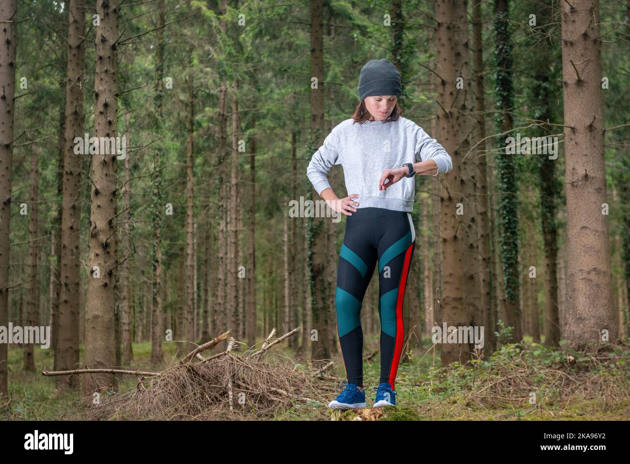 Fit Frau in Sportswear nutzt eine intelligente beobachten den Wald. Herzfrequenzüberwachung Stockfoto