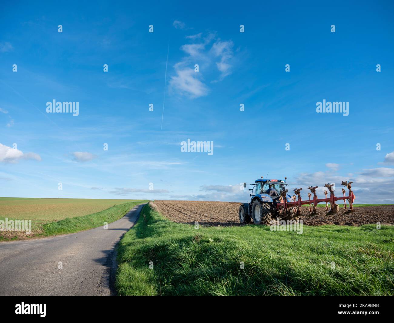 Traktor und Pflug auf dem Feld in ländlicher belgischer Landschaft in der Nähe von brüssel Stockfoto