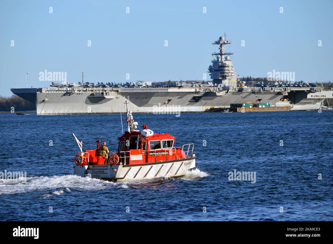 Der amerikanische Flugzeugträger USS Gerald R. Ford (CVN-78) mit dem Halifax-Feuerboot Kjipuktuk im Vordergrund. Halifax, Kanada. Stockfoto