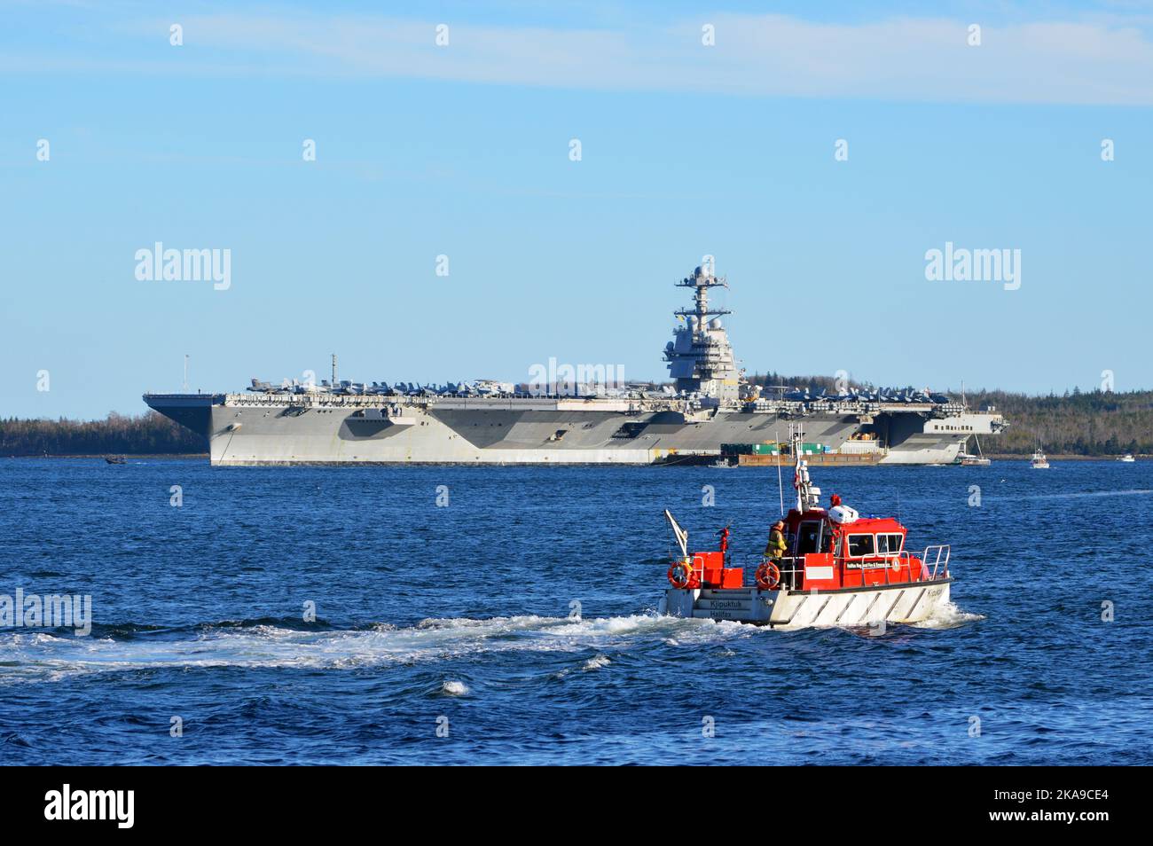 Der amerikanische Flugzeugträger USS Gerald R. Ford (CVN-78) mit dem Halifax-Feuerboot Kjipuktuk im Vordergrund. Halifax, Kanada. Stockfoto