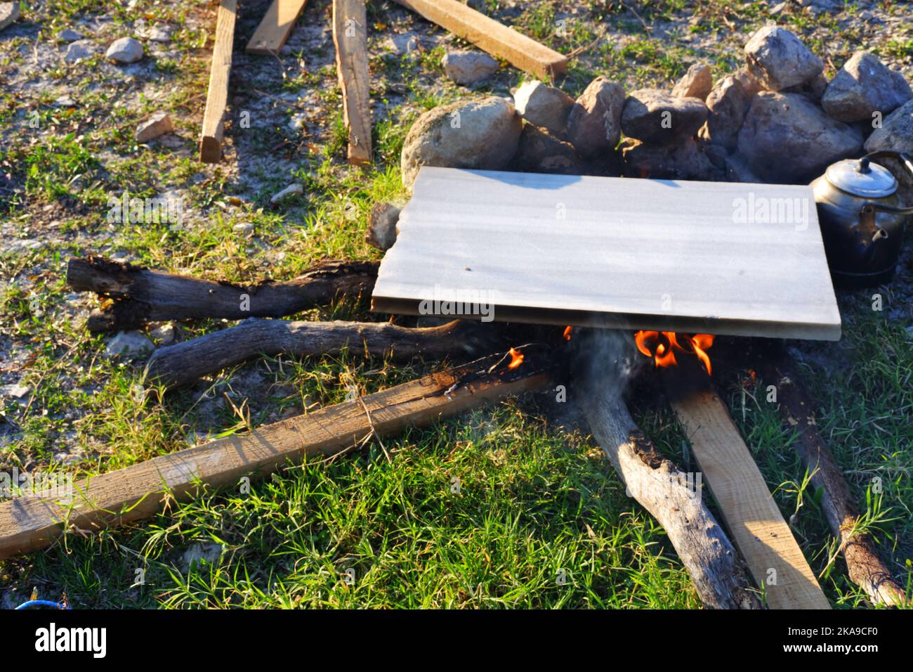 Marmor am Lagerfeuer zum Kochen und Teekannen am Feuer im Freien an einem sonnigen Sommertag Stockfoto