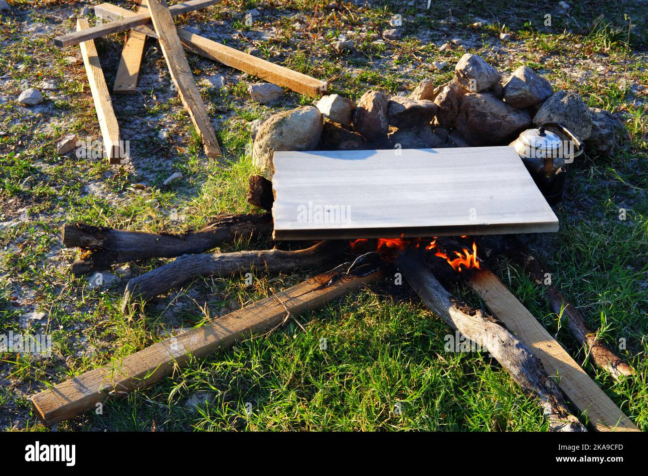 Marmor am Lagerfeuer zum Kochen und Teekannen am Feuer im Freien an einem sonnigen Sommertag Stockfoto