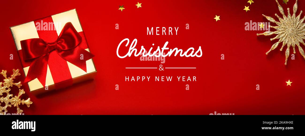 Weihnachts-Banner oder Grußkarten-Hintergrund mit weihnachts-Geschenkbox und goldener Dekoration auf rotem Hintergrund Stockfoto
