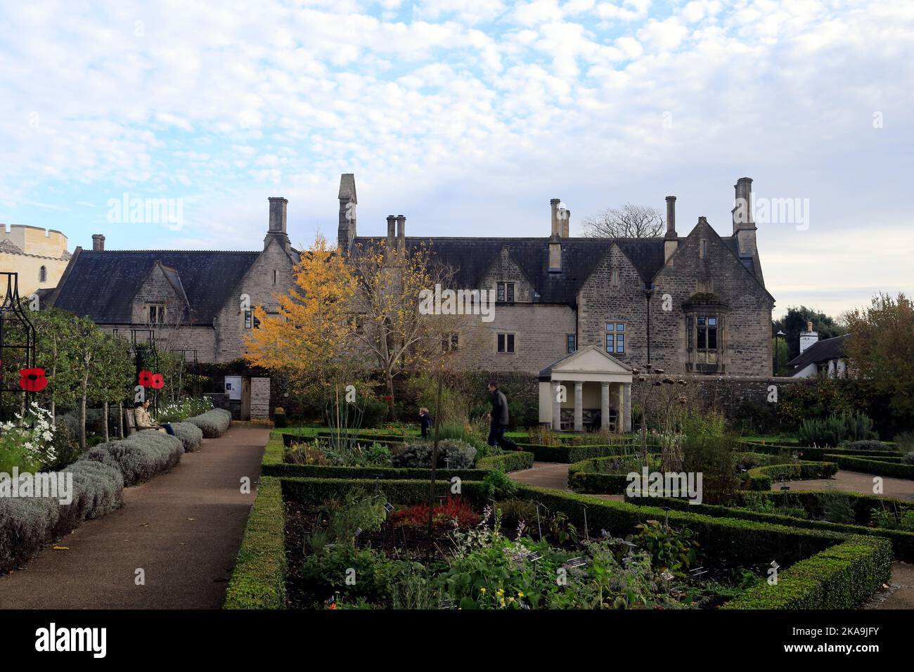 Cowbridge Physic Garden. Die junge Familie genießt die Gärten. Das alte Cowbridge Grammar School ist über der Mauer zu sehen. Stockfoto