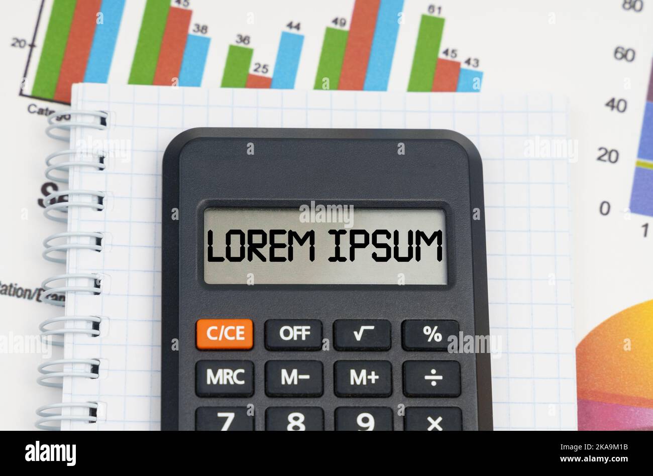 Business- und Economy-Konzept. Auf dem Tisch befinden sich Diagramme, ein Notizbuch und ein Rechner mit der Aufschrift - Lorem ipsum Stockfoto