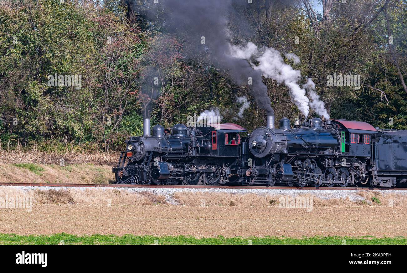 Ein Blick auf zwei Dampfmaschinen, Rauchschwaden und Dampfaufwärmung an einem sonnigen Tag nebeneinander Stockfoto