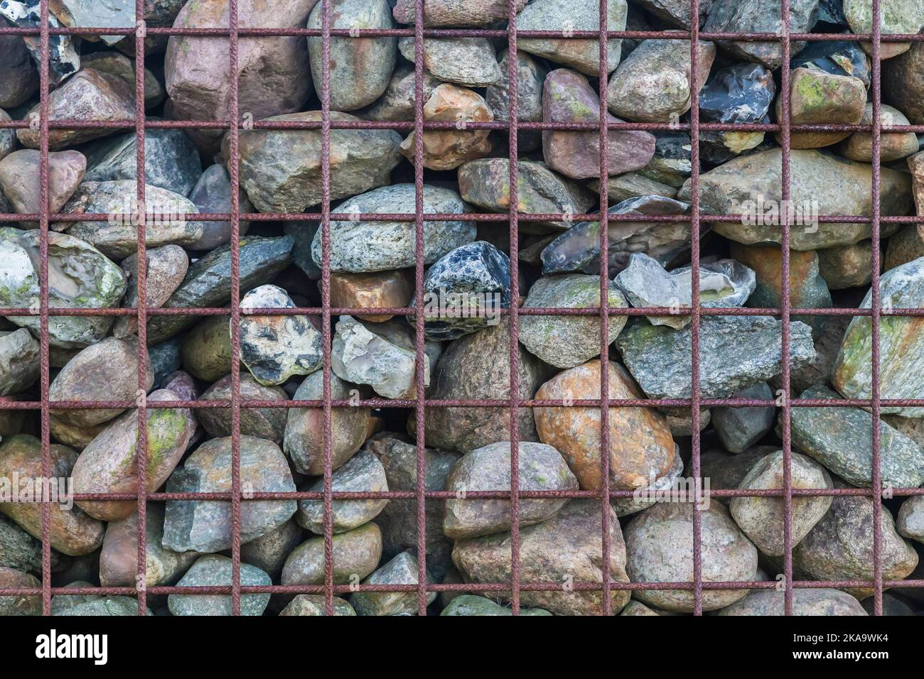 Steinzaun in einem Metallrahmen in Dänemark. Hintergrund Stockfoto
