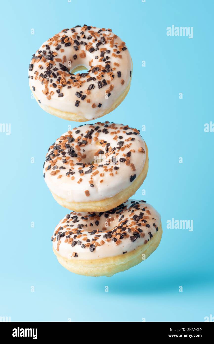 Kreatives Layout von frischen Donuts auf blauem Hintergrund. Minimales Lebensmittelkonzept. Stockfoto