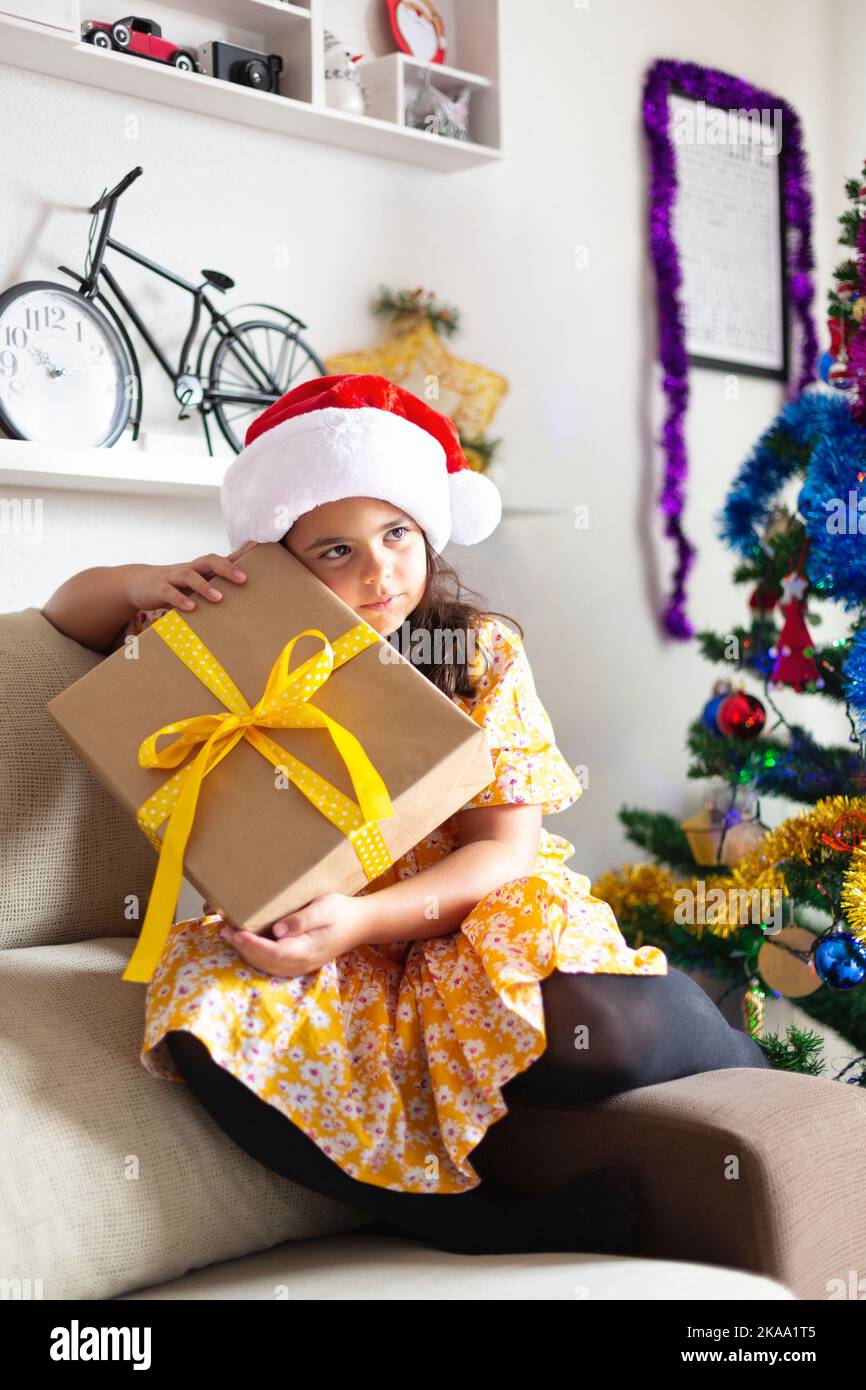 Kleines Mädchen zu Hause mit Geschenk vom Weihnachtsmann. Weihnachtszeit. Glückliche Momente. Stockfoto