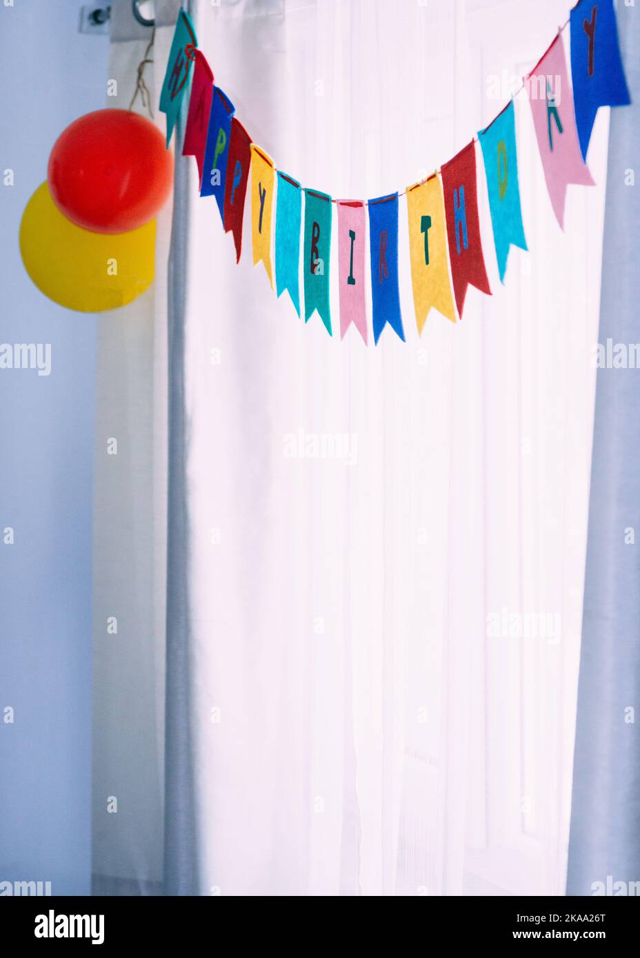 Happy Birthday Banner Party Hintergrund vor weißen Vorhängen und Tageslicht Stockfoto