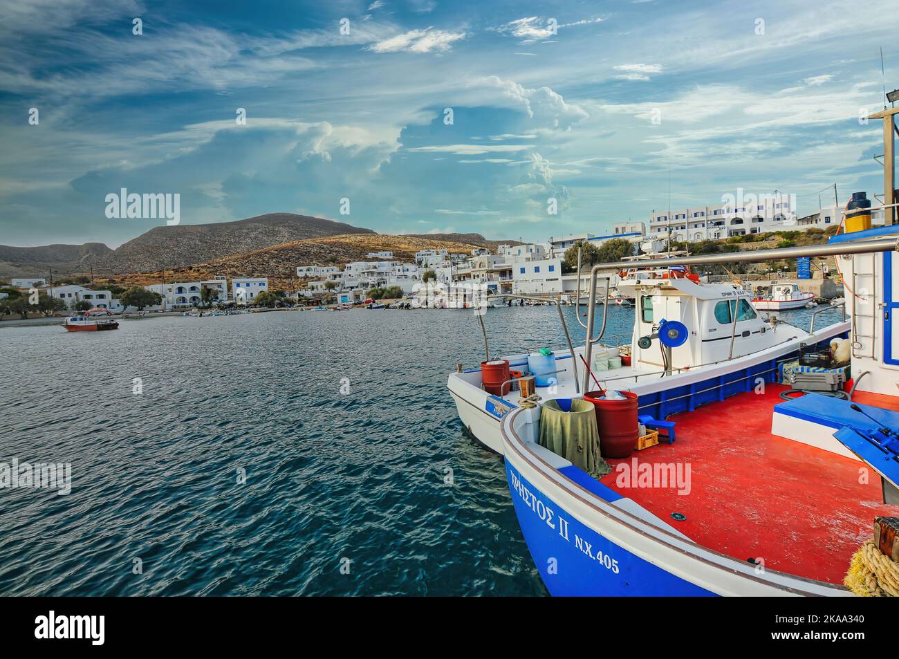 Ein schönes Boot im Meer in Karavostasi, Folegandros Island, Kykladen Griechenland mit einem blauen bewölkten Himmel Stockfoto