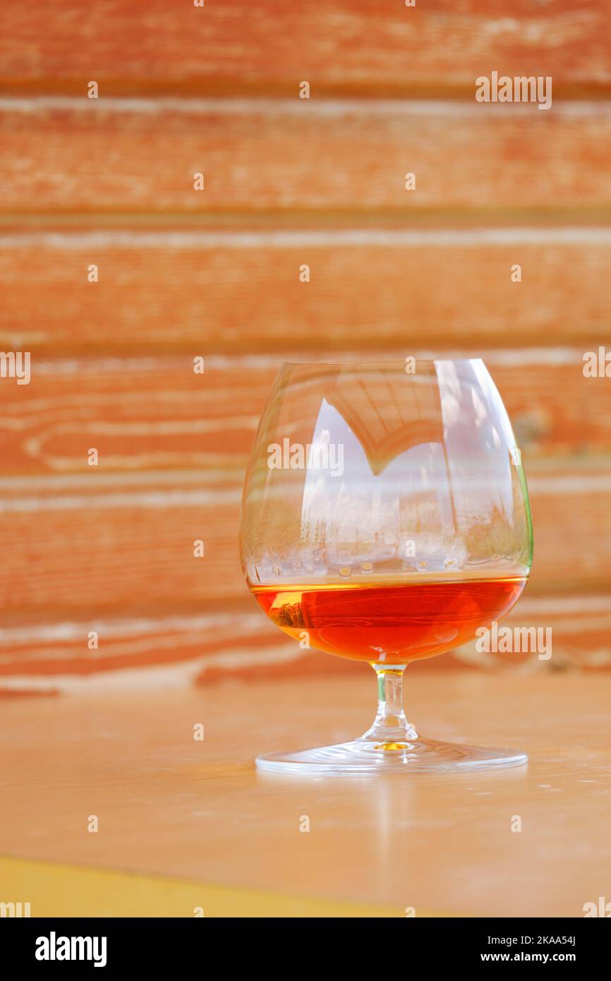 Whiskey und Cognac aus Snifter Cognac Glas mit Holzhintergrund Stockfoto
