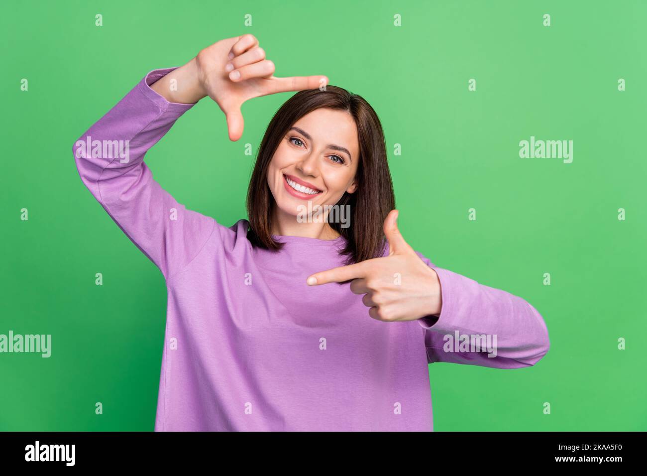 Portrait Foto von jungen wunderschönen Dame halten Finger Kader lächelnde Schauspielerin gute Laune auf grünem Hintergrund isoliert Stockfoto
