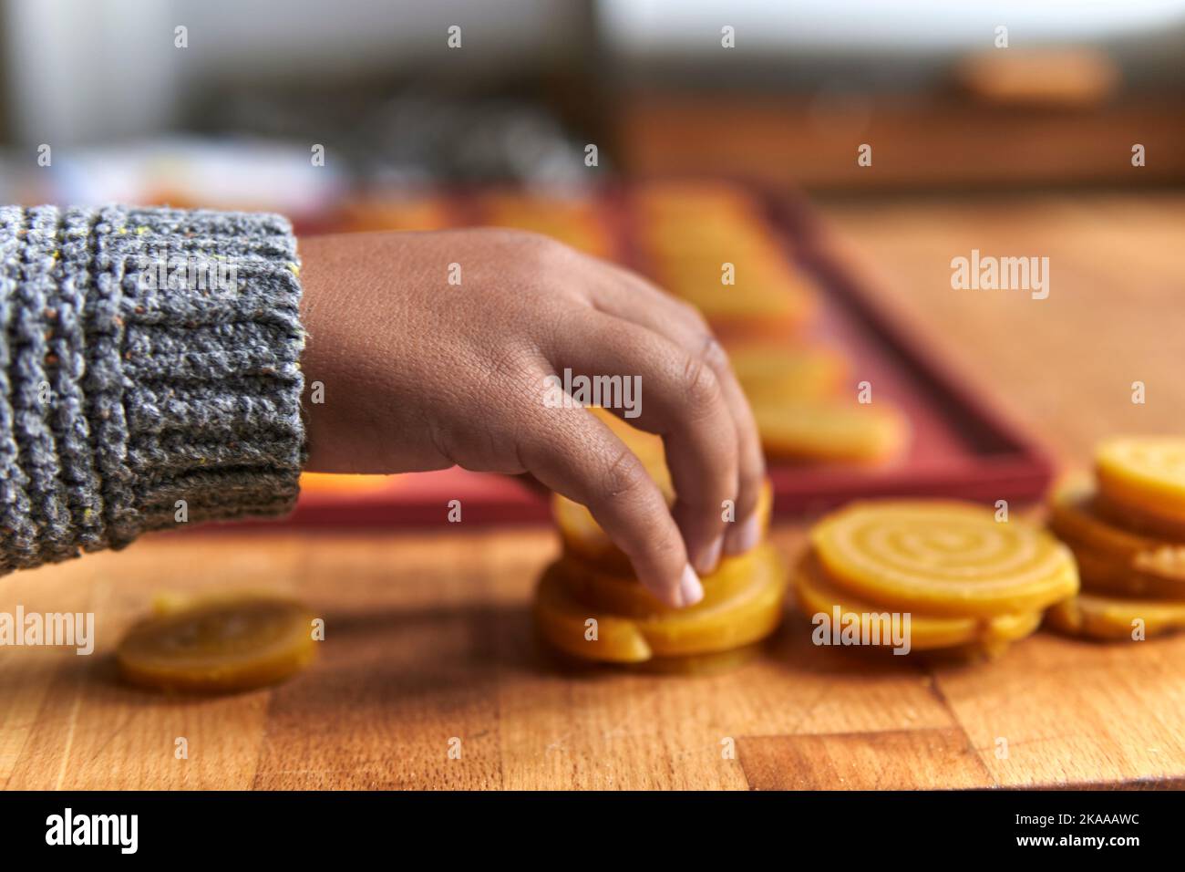 Junge im Elementaralter, der Cookies auf ein Silikontablett legte Stockfoto