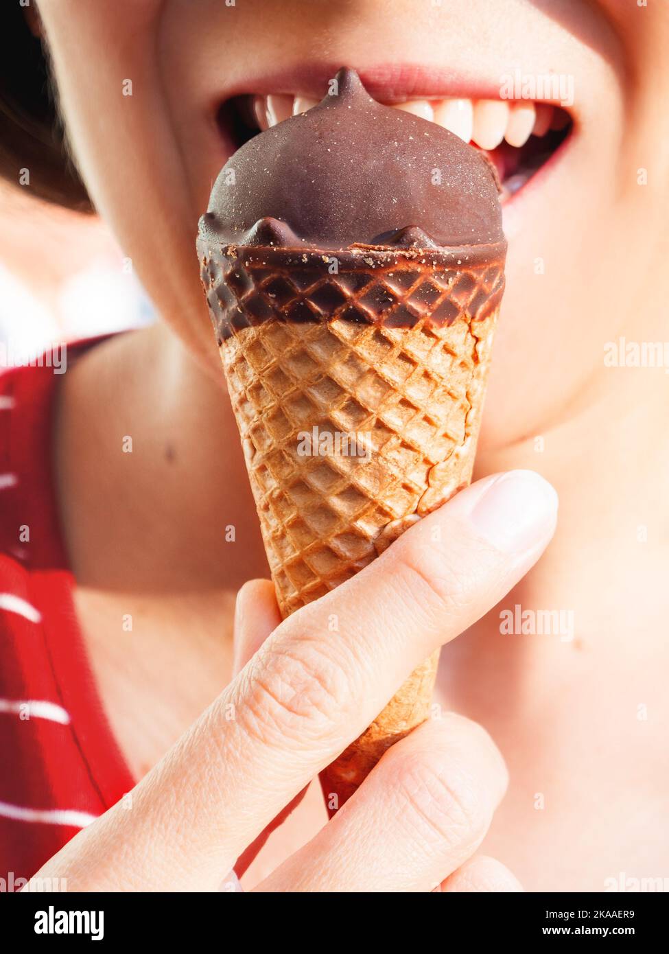 Frau im roten Hemd isst Eis. Nahaufnahme des kalten Nachtisch. Sommerspaß. Stockfoto