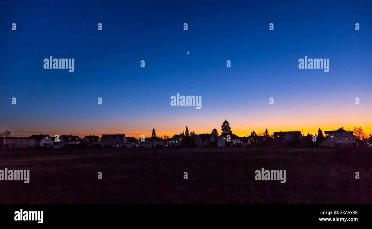 Sonnenuntergang in München im vorstädtischen Wohnbereich mit Mond Stockfoto