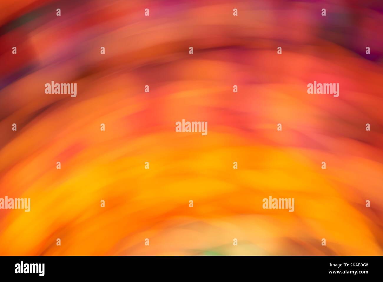 Farbenfroher dynamischer Hintergrund, abstrakt verschwommenes, fließendes Design, lebendige orange, gelbe und violette Lichter in Bewegung. Stockfoto