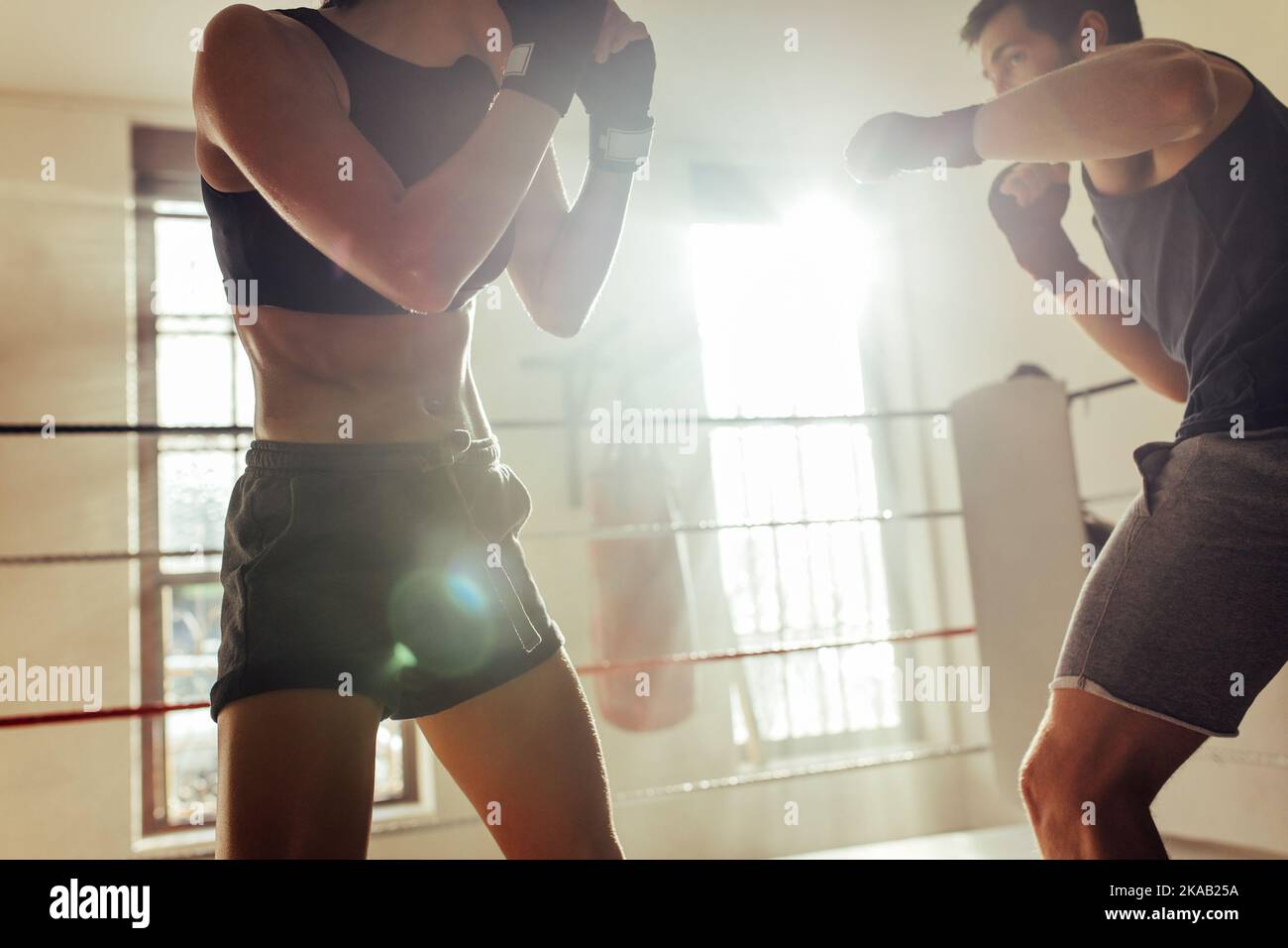 Zwei junge Boxer kämpfen in einem Boxring. Zwei junge Athleten stehen sich während eines Trainings in einer Boxhalle gegenüber. Stockfoto